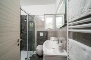 a bathroom with a toilet and a sink and a shower at Deluxe apartment in Mlini +28 photos