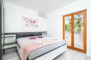 a white bedroom with a bed with red pillows at Deluxe apartment in Mlini