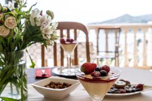 a table with a bowl of dessert and a bowl of fruit at Deluxe apartment in Mlini