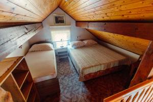 an attic bedroom with two beds in a room at Zidanica Bahor in Črnomelj