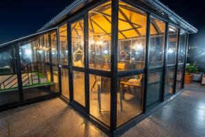 a glass house with a table in it at night at Balanchine in Kutaisi