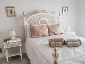a bedroom with a white bed with two pillows at Casa do gato branco in Furadouro