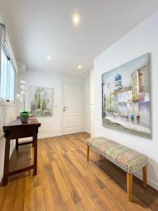 a living room with a bench and a painting on the wall at Apartamentos Sevilla in Valencia