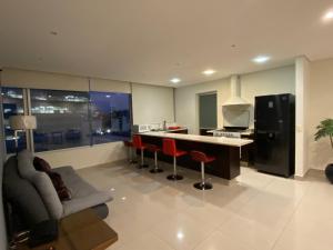 a kitchen with a bar and some red chairs at Apartamento de 2 habitaciones junto al WTC in Mexico City