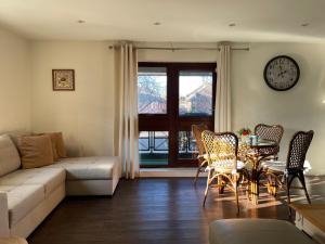 ein Wohnzimmer mit einem Sofa, einem Tisch und Stühlen in der Unterkunft St Georges Balcony Suite in Portsmouth