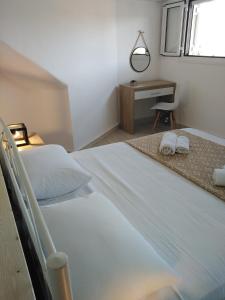a white bedroom with a bed and a desk at Apartment 2 for rent in Tzanata Kefalonia in Dhimisianáta