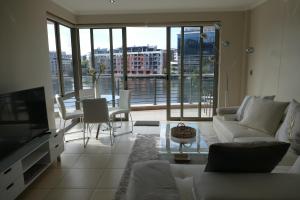 a living room with a couch and a tv at Little Venice Self Catering in Bellville