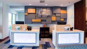 a waiting room with two tables and a clock on the wall at Holiday Inn Express & Suites Danville, an IHG Hotel in Danville