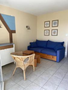a living room with a blue couch and a table at Pepper Lake in Fort-Mahon-Plage