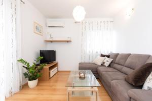 a living room with a couch and a tv at Apartments Stipančić in Krk