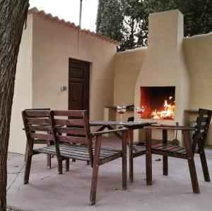 una mesa y 2 sillas con chimenea en Casa rural La Quinta De Lara, en Valdepeñas