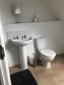 ein weißes Bad mit einem WC und einem Waschbecken in der Unterkunft Spring House - Staycation - Perfect for Contractors & Families - 2 Parking Spaces in Dudley