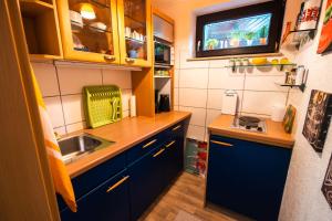 una pequeña cocina con armarios azules y fregadero en Erholungskellerchen, en Bad Lippspringe