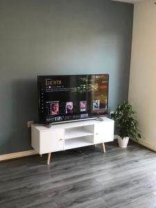 a flat screen tv sitting on top of a white entertainment center at Spring House - Staycation - Perfect for Contractors & Families - 2 Parking Spaces in Dudley