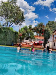un grupo de personas nadando en una piscina en La Diligencia Cabañas Campestres en Morelia