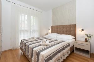 a bedroom with a large bed with a large window at Apartments Stipančić in Krk