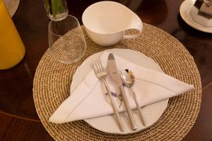 einem Tisch mit einer Platte mit einem Messer und einer Gabel in der Unterkunft Cathy's Luxury Home in Rom