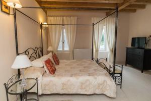 1 dormitorio con cama con dosel y TV en Maison harmonie en Buzy
