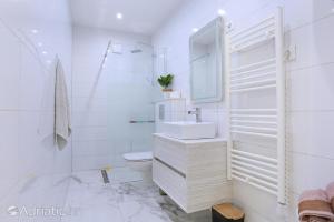 a white bathroom with a sink and a toilet at Apartments Bagaric in Trogir +62 photos