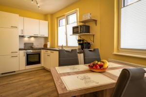 a kitchen with a table with a bowl of fruit on it at Im Unterdorf Apartments Rust in Rust