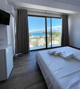 a hotel room with a bed and a large window at Hotel Lula Ksamil in Ksamil