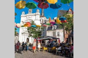 a group of colorful umbrellas hanging over a street at L’escapade : maison centre-ville avec cour in Saumur