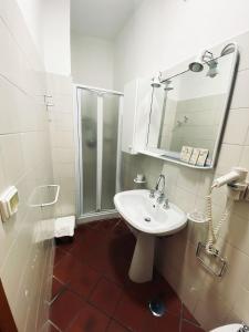 a white bathroom with a sink and a shower at Caterina House Nel borgo piú bello d'Italia in San Lucido