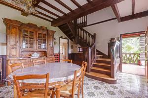 une salle à manger avec une table, des chaises et un escalier dans l'établissement Magnificent chalet on the heights of Veyrier-du-Lac - Welkeys, à Veyrier-du-Lac