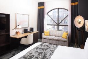 Pokój hotelowy z łóżkiem, biurkiem i kanapą w obiekcie Saint Kate - The Arts Hotel w mieście Milwaukee