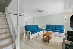 ein Wohnzimmer mit 2 blauen Stühlen und einem Tisch in der Unterkunft Gulf Winds #25 in Destin