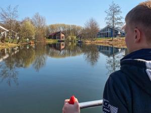 a boy on a boat looking at a lake at 6 person holiday home in Otterndorf in Otterndorf