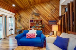 a living room with a blue couch and wooden walls at Lake Therapy in Lakeshore