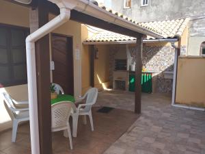 un pergolato con tavolo e sedie su un patio di Casa da Celia 02 ad Arraial do Cabo