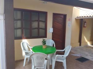 a green table and chairs in a room at Casa da Celia 02 in Arraial do Cabo