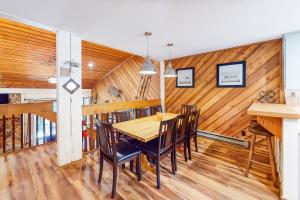 a dining room with wooden walls and a table and chairs at Lake Therapy in Lakeshore