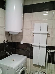 y baño con lavadora y armario. en B3 Sneznik-Modern apartment en Vrnjačka Banja