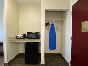 a room with a kitchen with a microwave and a blue door at Comfort Inn East Windsor - Springfield in East Windsor