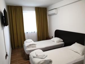 um quarto de hotel com duas camas e uma janela em Paradise Park em Polski Trŭmbesh