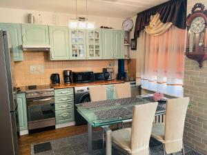 a kitchen with green cabinets and a table and chairs at Avelana Apartment in Pärnu