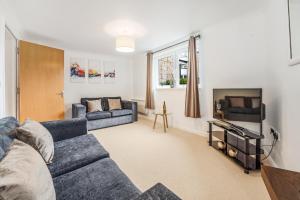 a living room with a couch and a tv at Saughton Suite in Edinburgh
