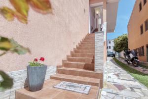 a staircase leading up to a building with a vase with flowers at Holiday Home & Apartments Primavera in Pula