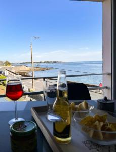 una tavola con un bicchiere di vino e un piatto di cibo di Studio face à la mer a Concarneau