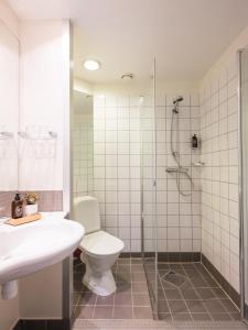 ein Bad mit einem WC und einer Dusche in der Unterkunft Villa Bryggekanten - by Classic Norway Hotels in Henningsvær
