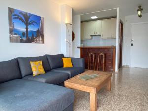 - un salon avec un canapé bleu et une table dans l'établissement Acapulco Playa 306 Apartments Casasol, à Nerja