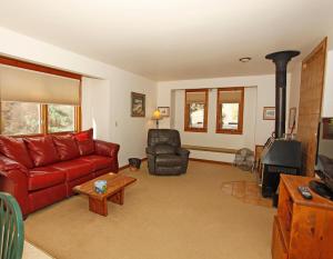 a living room with a red couch and a fireplace at River Park 1245 in Ouray