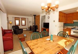 a kitchen and living room with a wooden table and chairs at River Park 1245 in Ouray