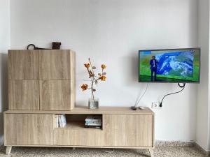 - une télévision à écran plat installée au-dessus d'un centre de divertissement en bois dans l'établissement Acapulco Playa 306 Apartments Casasol, à Nerja