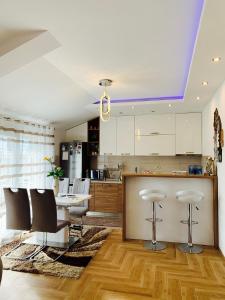 a kitchen with white cabinets and a table and chairs at DiVino Apartment in Tivat