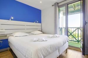 sypialnia z dużym białym łóżkiem i oknem w obiekcie Modern flat with three balconies in Biarritz - Welkeys w Biarritz
