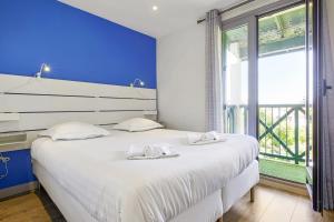 ビアリッツにあるAppartement Barbeau - Welkeysの大きな白いベッドと窓のある寝室